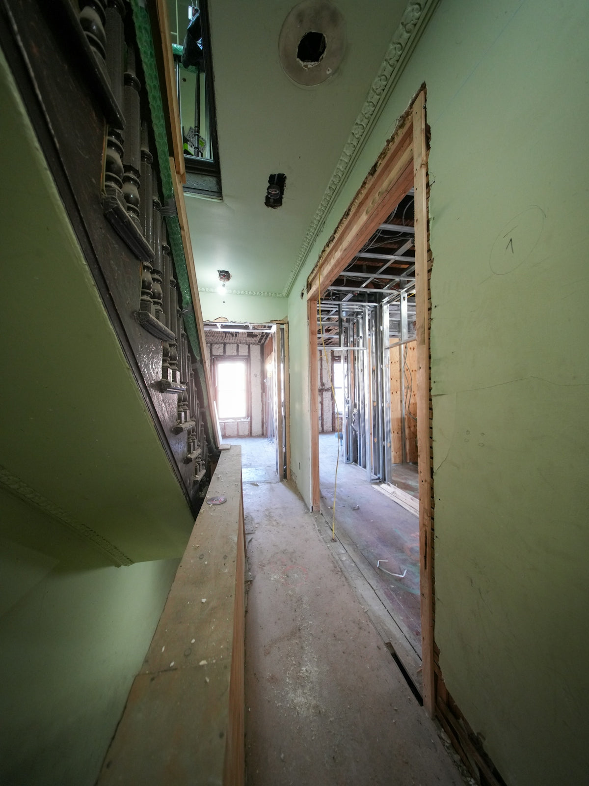 Interior hallway under renovation with exposed studs and doorway